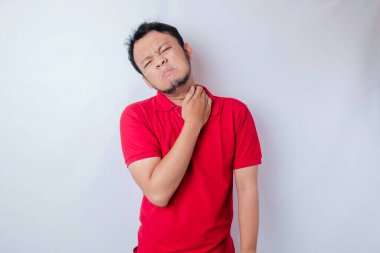 Asyalı bir adamın portresinin beyaz arka plan tarafından izole edilmiş boyun ve omuz ağrısı vardır.