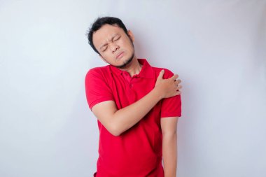 Asyalı bir adamın portresinin beyaz arka plan tarafından izole edilmiş boyun ve omuz ağrısı vardır.