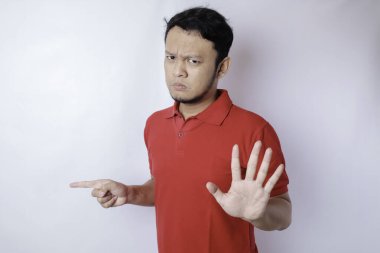 El hareketleriyle çekici Asyalı adam, yan tarafındaki fotokopi alanını gösterirken reddedilme ya da yasaklama pozu veriyor.