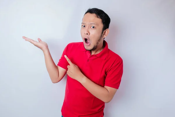Chockad Asiatisk Man Bär Röd Shirt Pekar Kopieringsutrymmet Bredvid Honom — Stockfoto