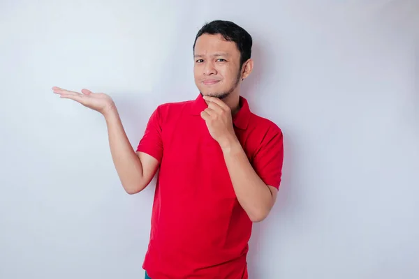 Portrét Přemýšlivého Mladého Ležérní Muž Červené Košili Ukazuje Stranou Izolované — Stock fotografie