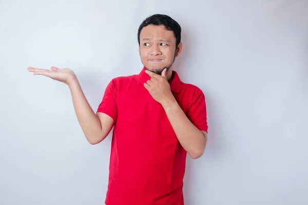 Retrato Jovem Pensativo Casual Vestindo Uma Camisa Vermelha Apontando Para — Fotografia de Stock