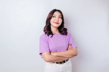 Düşünceli bir genç kızın portresi eflatun bir gömlek giymiş beyaz arka planda soyutlanmış bir kenara bakıyor.