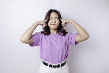 Düşünceli bir genç kızın portresi eflatun bir gömlek giymiş beyaz arka planda soyutlanmış bir kenara bakıyor.