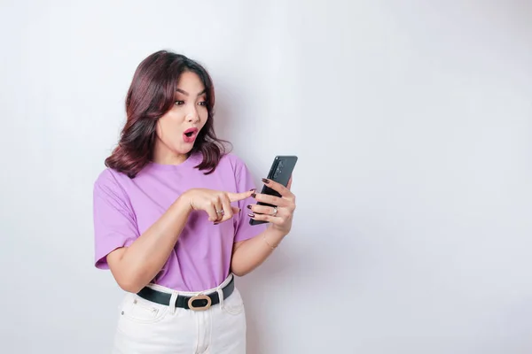 Έκπληκτη Ασιάτισσα Που Φοράει Λιλά Μωβ Μπλουζάκι Δείχνοντας Smartphone Της — Φωτογραφία Αρχείου