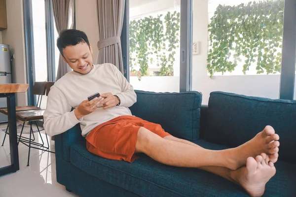 Ung Asiatisk Mann Tilbringer Fritiden Hjemme Med Sitte Koselig Sofa – stockfoto