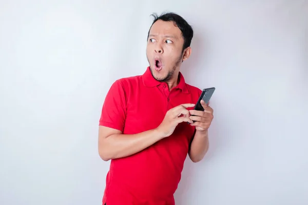 Überraschter Asiatischer Mann Rotem Shirt Zeigt Auf Sein Smartphone Isoliert — Stockfoto