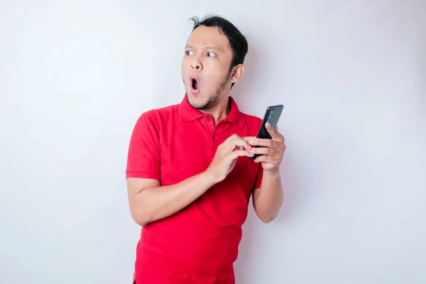 Überraschter Asiatischer Mann Rotem Shirt Zeigt Auf Sein Smartphone Isoliert — Stockfoto