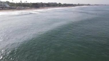 Öğleden sonra sörfçülerle Canggu sahilinin hava manzarası.