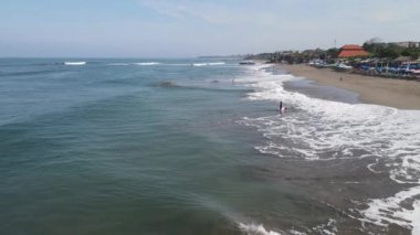 Öğleden sonra sörfçülerle Canggu sahilinin hava manzarası.