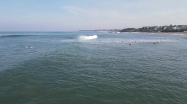 Aerial view of people surfing on waves with surfboards when vacation in Bali, Indonesia .
