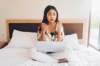 Yataktan çalışan üzgün genç bir kadın. Dizlerinin üzerine çök ve kızgın bir hareket göster.