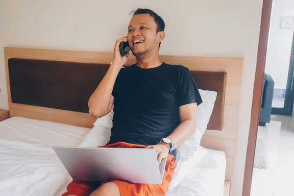 Pria Muda Yang Bahagia Bekerja Dari Tempat Tidur Pegang Laptop — Stok Foto