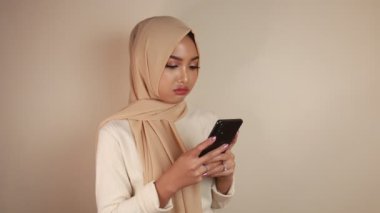 Asyalı güzel kız beyaz gömlekli akıllı telefondan şoke oldu.