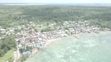 Endonezya 'nın Maluku şehrinde küçük bir adanın bulunduğu güzel sahil yakınlarındaki köyün hava manzarası.
