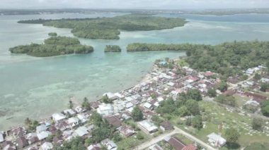 Endonezya 'nın Maluku şehrinde küçük bir adanın bulunduğu güzel sahil yakınlarındaki köyün hava manzarası.