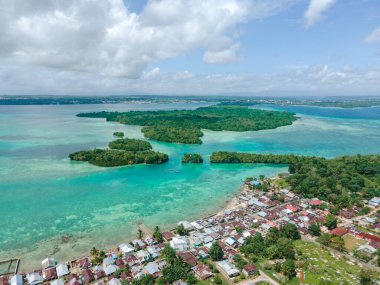 Endonezya 'nın Maluku şehrinde küçük bir adanın bulunduğu güzel sahil yakınlarındaki köyün hava manzarası.
