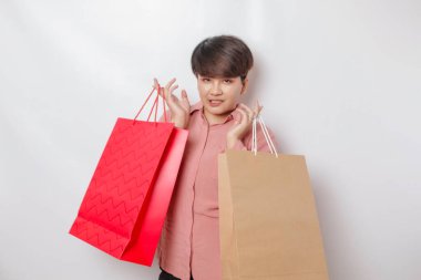 Mutlu genç bir kadın pembe gömlek giyer ve elinde hediyeler ya da alışveriş çantası taşır..