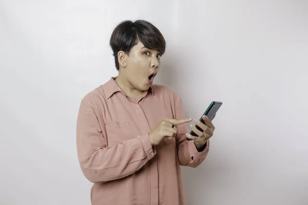 Überraschte Kurzhaarige Asiatin Rosa Hemd Die Auf Ihr Smartphone Zeigt — Stockfoto