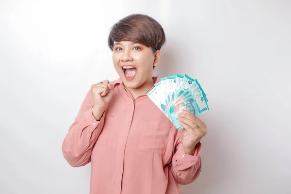 Šťastná Mladá Žena Sobě Růžovou Košili Drží Peníze Hotovosti Indonéské — Stock fotografie