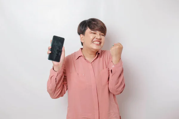 一个快乐的亚洲女人的画像正在微笑 并在智能手机上显示出她穿着粉色衬衫 被白色背景隔开的复制空间 — 图库照片