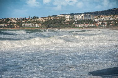 Güçlü bir Kasım rüzgarı, kıyıya doğru kükreyen dalgalar salıyor ve beyaz köpükleri kopartıyor. Paphos ve yakındaki köylerin tüm plajları fırtınalı sularla doludur..       