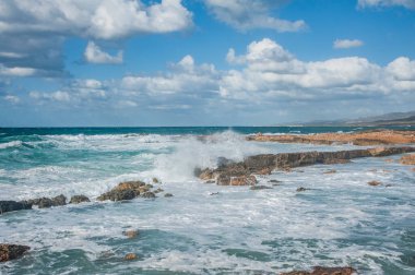 Güçlü bir Kasım rüzgarı, kıyıya doğru kükreyen dalgalar salıyor ve beyaz köpükleri kopartıyor. Dalgalar kayalık kıyılara çarpar, milyonlarca su sıçraması ile havayı doyurur..       