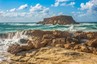 Güçlü bir Kasım rüzgarı, kıyıya doğru kükreyen dalgalar salıyor ve beyaz köpükleri kopartıyor. Dalgalar kayalık kıyılara çarpar, milyonlarca su sıçraması ile havayı doyurur..       