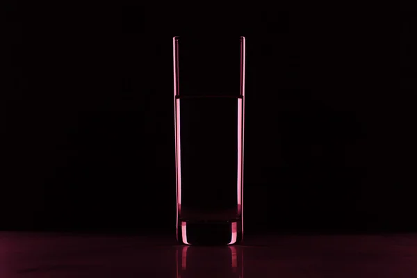 Glas met water in het donker — Stockfoto