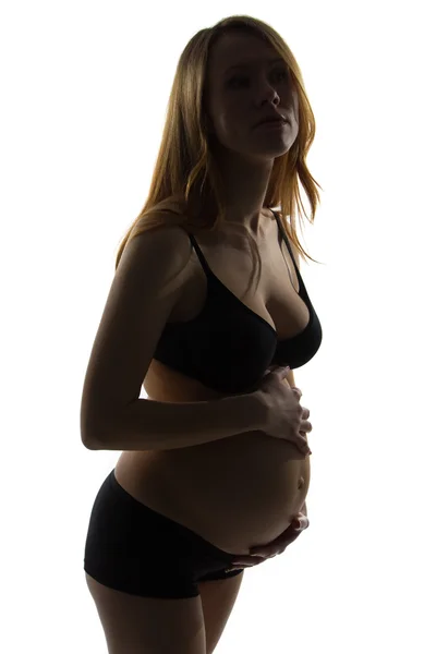 Gravid kvinna med händerna över magen — Stockfoto