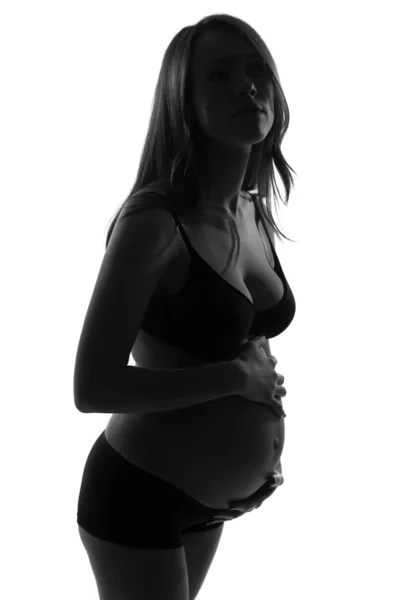 Gravid kvinna med händerna över magen — Stockfoto