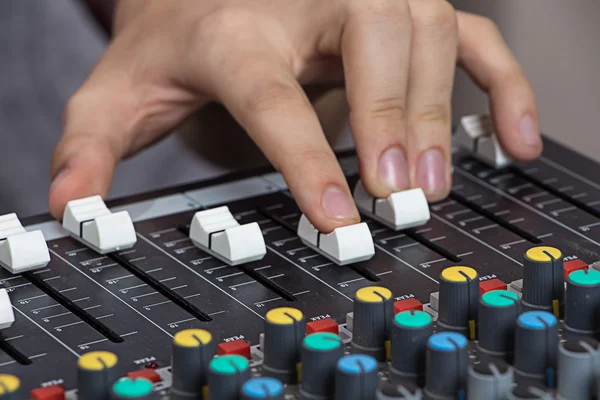 Mãos operando console de som — Fotografia de Stock