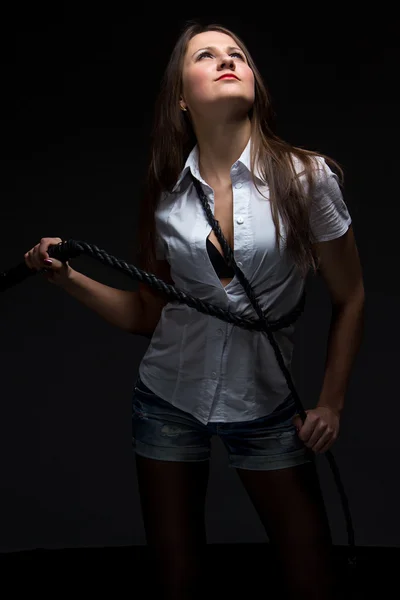 Woman in shadow with whip — Stock Photo, Image