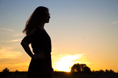 Gün batımında bir kızın silueti