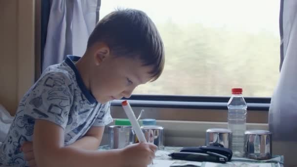 Ötéves fiú rajzol a mozgó vonaton — Stock videók