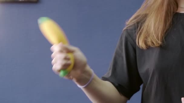 Film kobiety potrząsającej bananową zabawką w ręku — Wideo stockowe