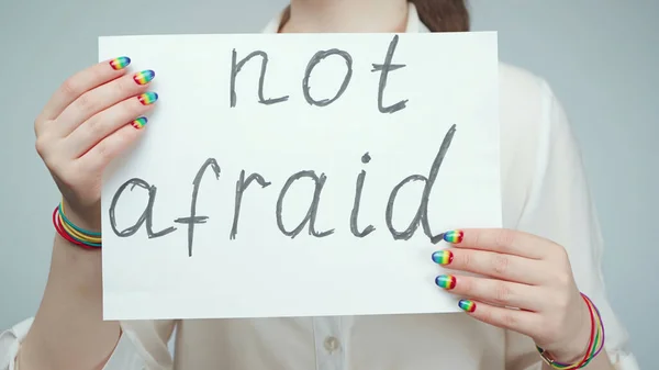 Photo of girl with rainbow nails holding poster — Stock Photo, Image