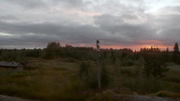 Zonsondergang in bewolkt dagzicht vanuit bewegend treinraam — Stockvideo