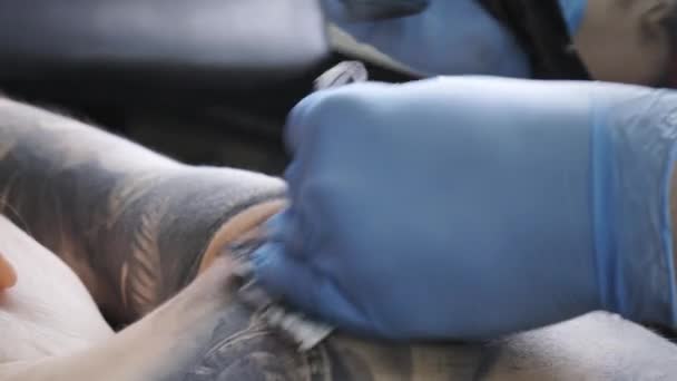 Imágenes de primer plano del hombre haciendo tatuaje en la espalda femenina — Vídeo de stock