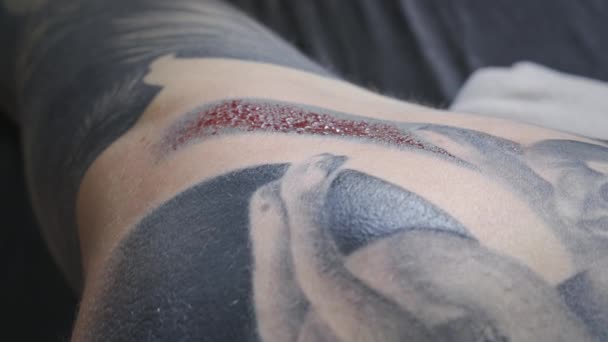 Видео, где женщина возвращается с капельками крови во время татуировки — стоковое видео