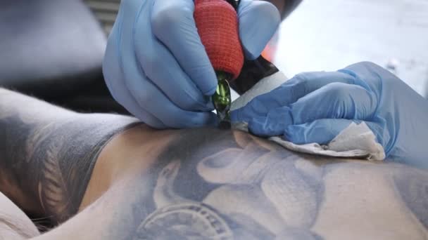 Primer plano de vídeo del hombre haciendo tatuaje en la espalda femenina — Vídeos de Stock