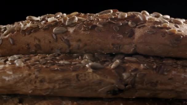 Beelden van draaiend brood met vlas en zonnebloempitten — Stockvideo