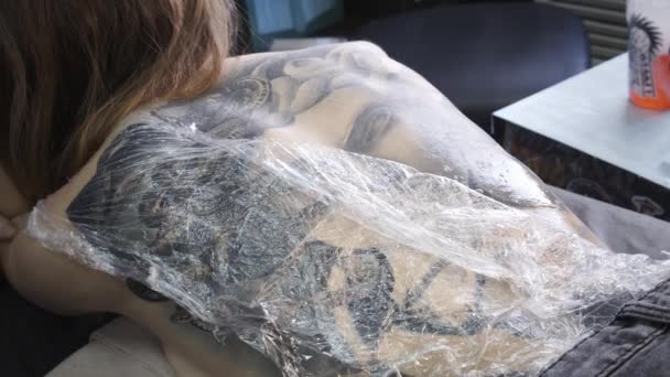 Video de mujeres de vuelta con tatuaje durante desinfectar — Vídeos de Stock