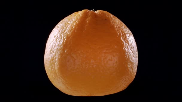 Girando naranja sobre fondo negro aislado — Vídeo de stock