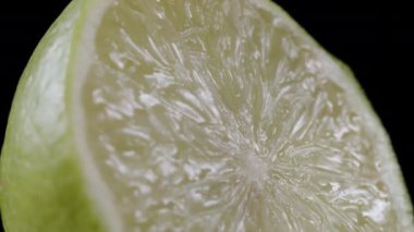 Siyah arkaplanda dilimlenmiş yeşil dönen limon