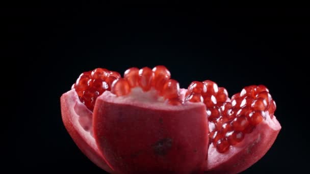 Video rotující semena granátového jablka na černém pozadí — Stock video