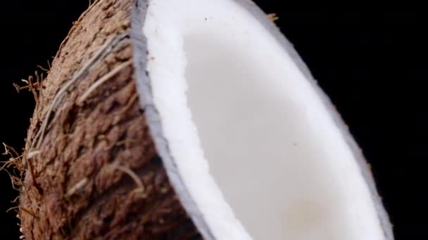 在黑色背景上旋转椰子一半的射击 — 图库视频影像