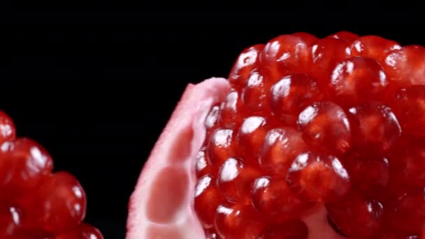 Shooting of rotating red pomegranate seeds on black background — Stock Video