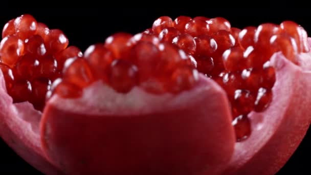 Closeup video of rotating pomegranate seeds on black background — Stock Video