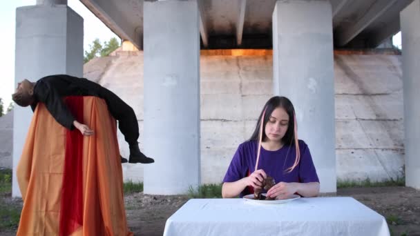 Filmaufnahmen von Frau, die rohe Leber isst und Mann hinter sich liegend — Stockvideo